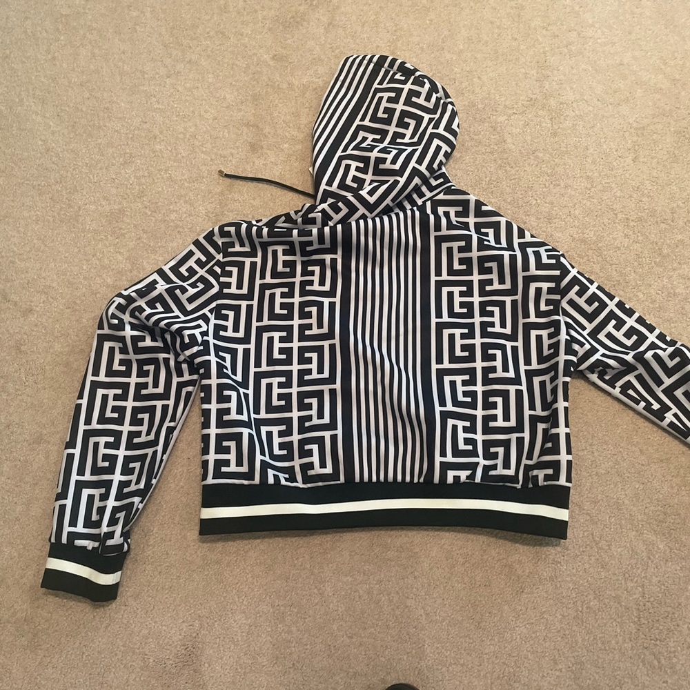 Balmain knit hoodie and wide-leg slacks.